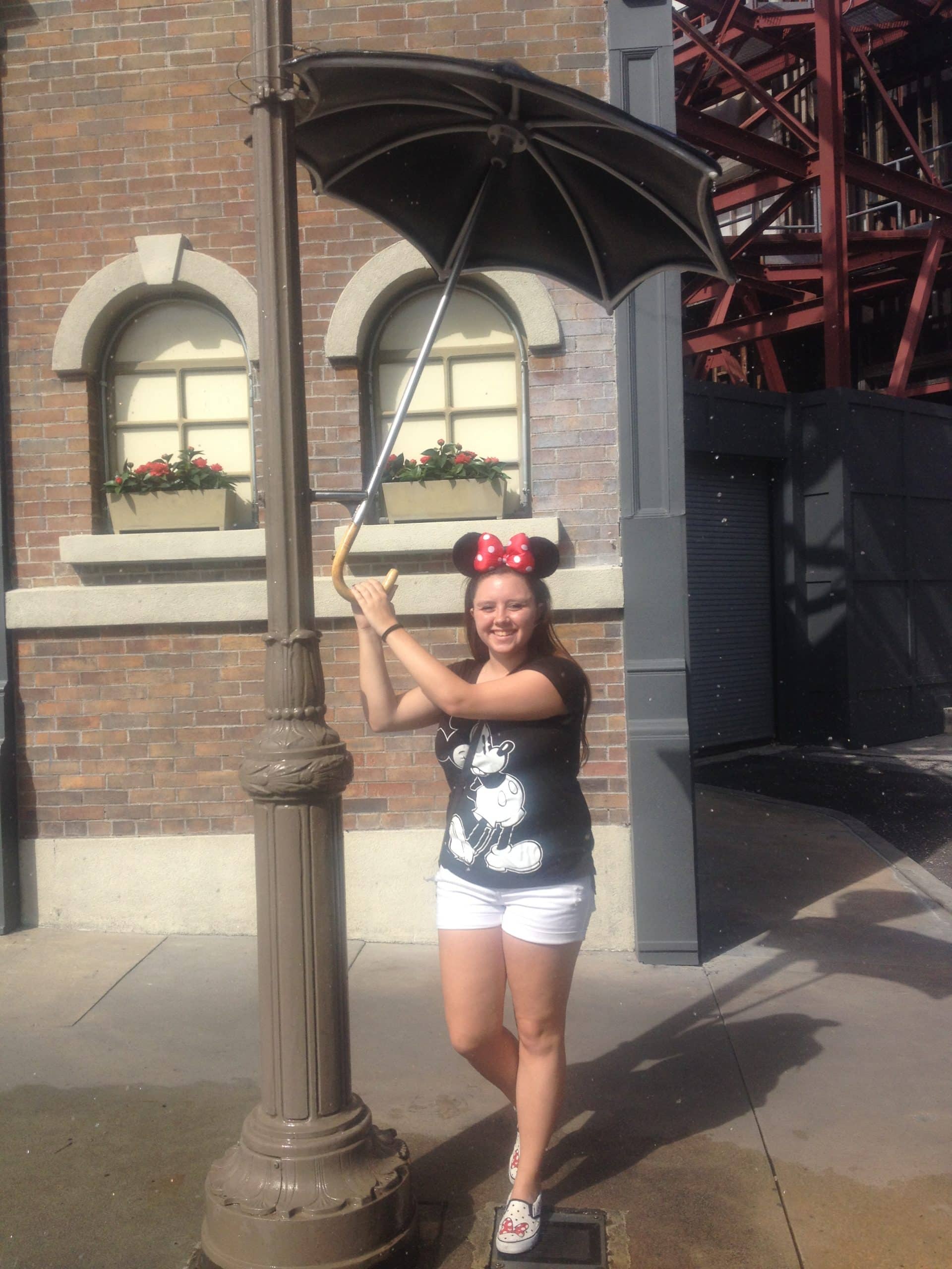 posing with the Singin in the Rain umbrella on the Streets of America at Hollywood Studios