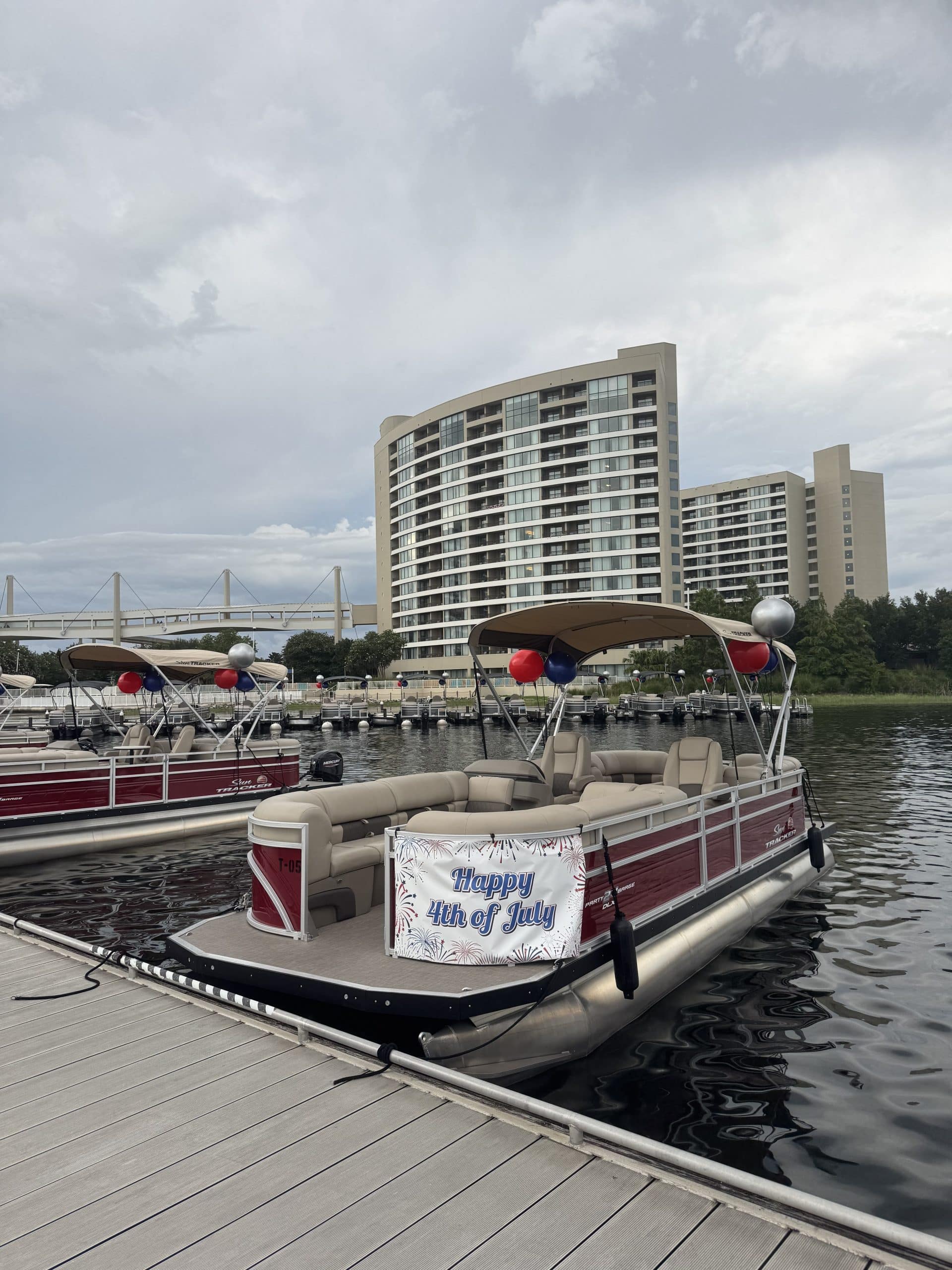Fourth of July fireworks cruise pontoon boats with "Happy 4th of July" signs